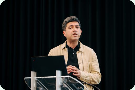 Morteza Azizi speaking at a lectern at CBX Tech University 2026